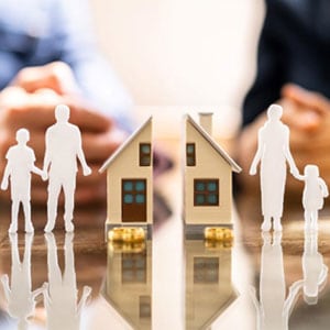 Family members holding paper cutouts of a house and family, symbolizing unity and love