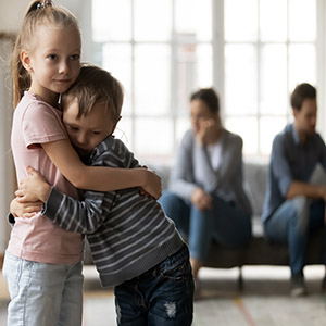 Distressed children hugging while parents argue in the background over divorce and infidelity in Nebraska.